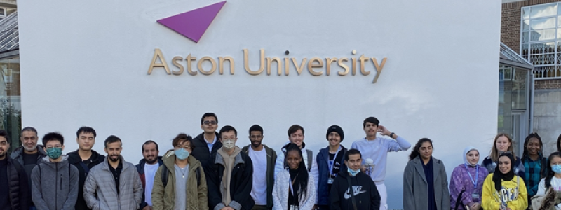 OnCampus Aston students on the university campus, in front of logo